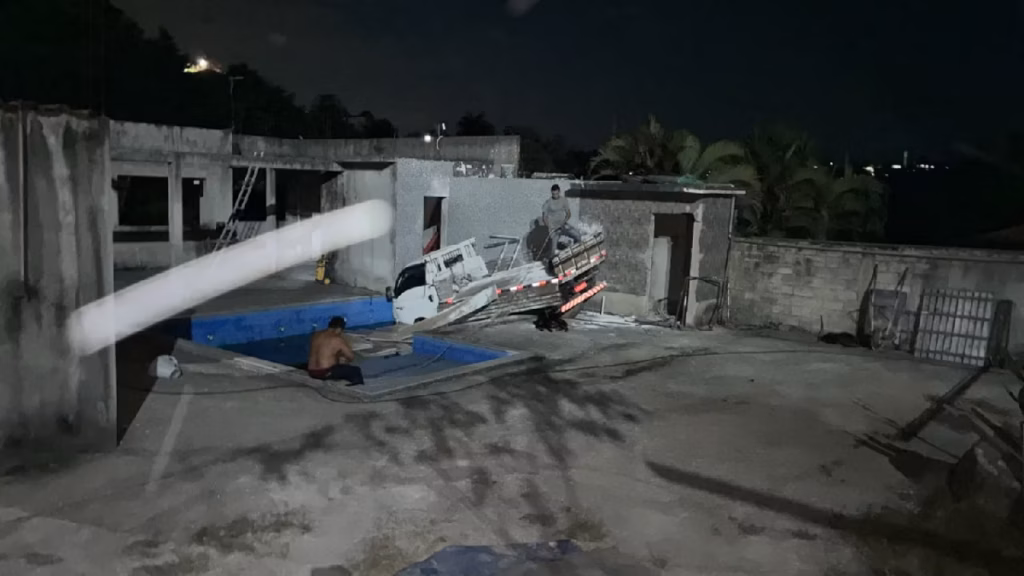 Motorista perde o controle da direção e caminhão cai dentro de piscina
